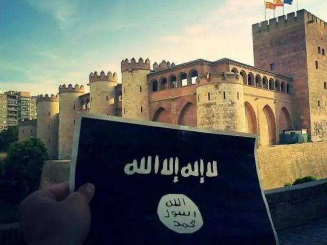 La Guardia Civil descubrió que el investigado había subido esta fotografía de la bandera de Dáesh con el palacio de La Aljafería detrás.