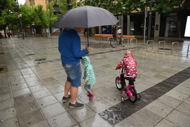 La lluvia también ha hecho acto de presencia en las calles de Huesca.
