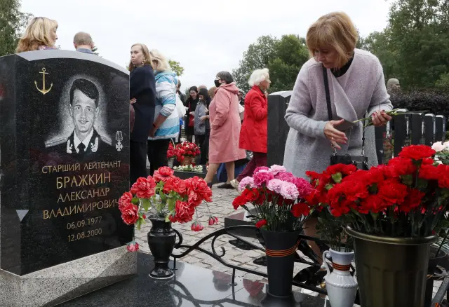Familiares de los fallecidos visitan sus restos en un cementerio en San Petesburgo