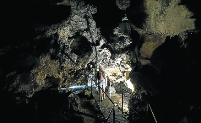 Un grupo de turistas camina por el interior de la misteriosa Cueva del Agua de Fuentespalda.