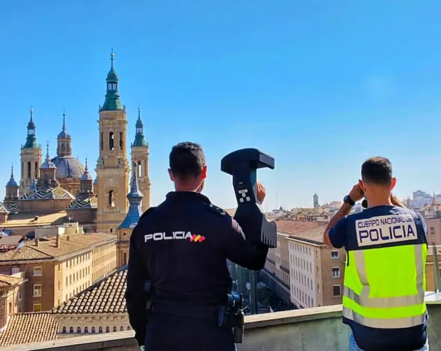Dos agentes vigilan con un antidrón el cielo de Zaragoza.