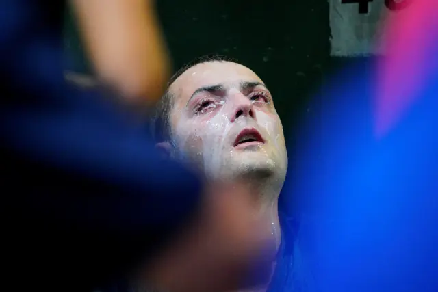 A man looks on after being pepper sprayed during a Melbourne rally supporting Novak Djokovic, in Melbourne