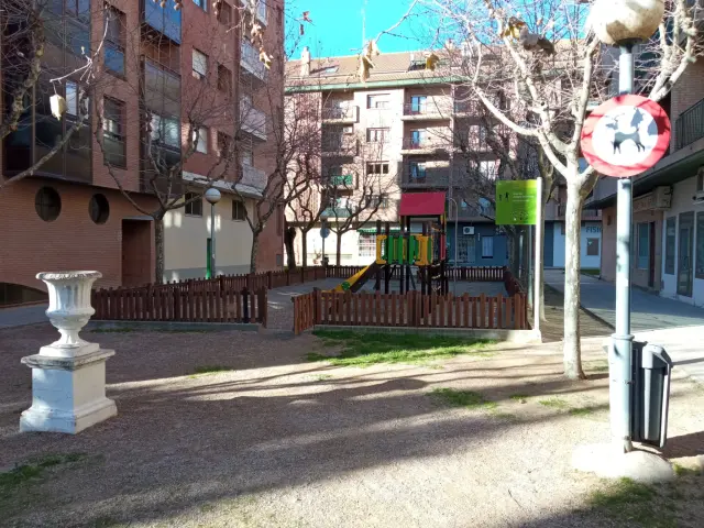 En la travesía Casado del Alisal de Huesca hay una zona de juegos infantiles y dos señales que prohíben la entrada de perros.