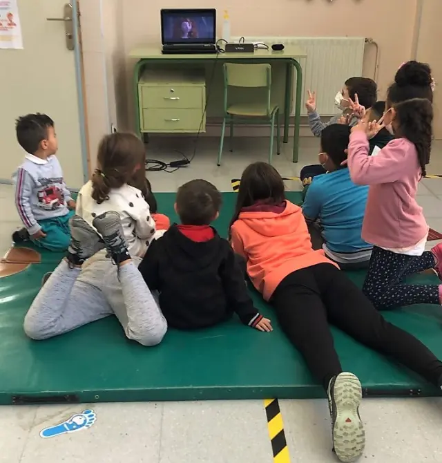 Niños del colegio disfrutando de una película en el aula.