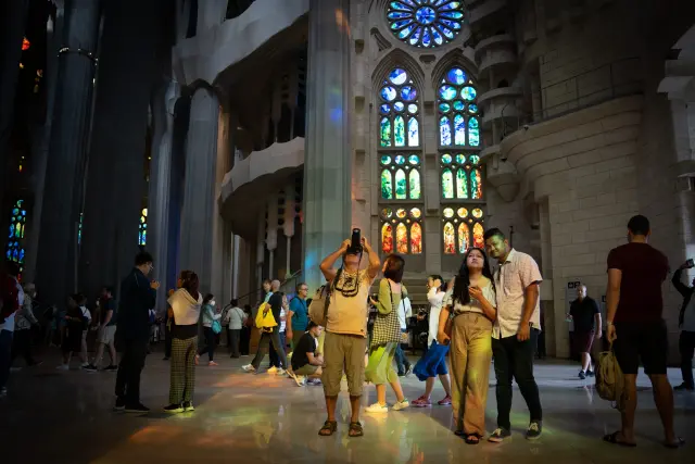 Turistas visitan y fotografían la Sagrada Familia en Barcelona.