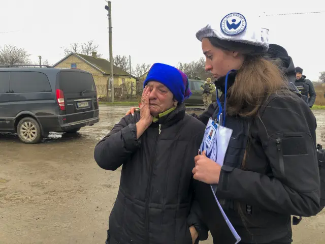 Una mujer llora ante una voluntaria en Blagodatne.