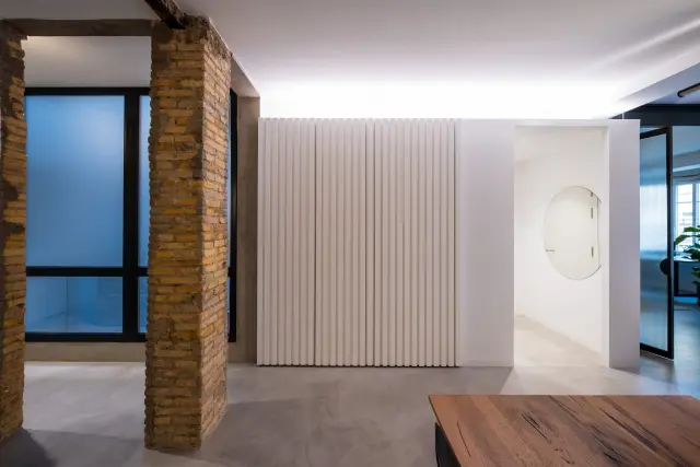 El interior de una vivienda reformada en Zaragoza, donde predomina el color blanco con detalles en negro.