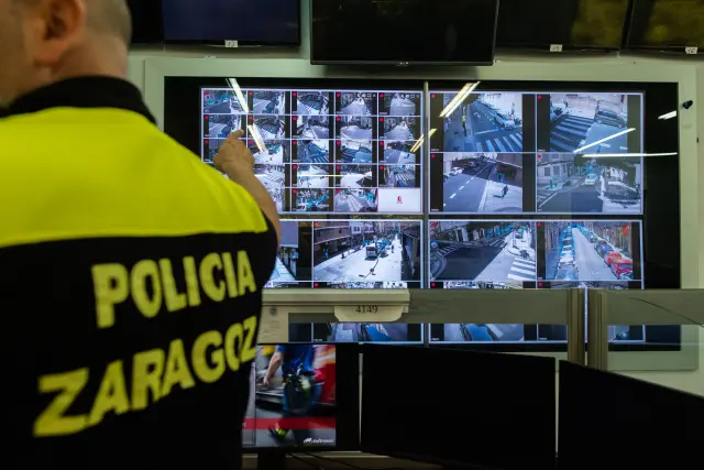 Un policía señala a una pantalla donde se muestran las imágenes de las cámaras.