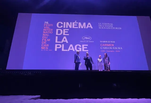 Antonio Saura, Anna Saura y María Esteve, junto al presentador del acto en Cannes.