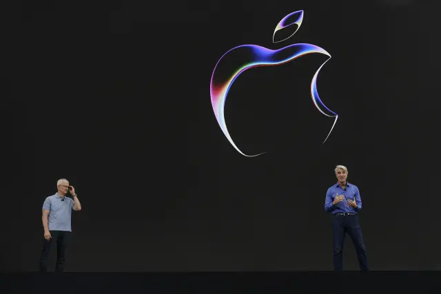 Apple CEO Tim Cook, left, joins Craig Federighi, Senior vice president of Software Engineering, on stage during an announcement of new products on the Apple campus Monday, June 5, 2023, in Cupertino, Calif. (AP Photo/Jeff Chiu)