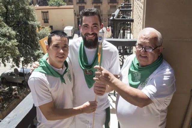 Raúl Bernal sostiene el cohete de las fiestas de San Lorenzo 2023 de Huesca con Jesús Martínez y Gonzalo Hernández, de la Pirotecnia Oscense.