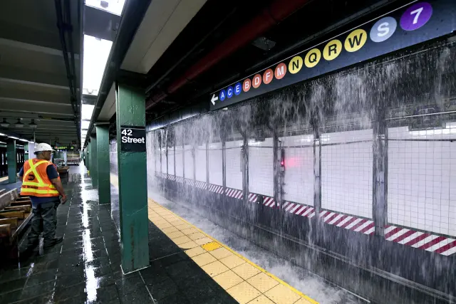 El agua de una tubería principal cae en cascada hacia la estación de metro Times Square de Nueva York.