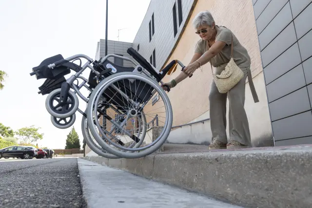 María Pilar Gimeno demuestra cómo baja la silla a la carretera.