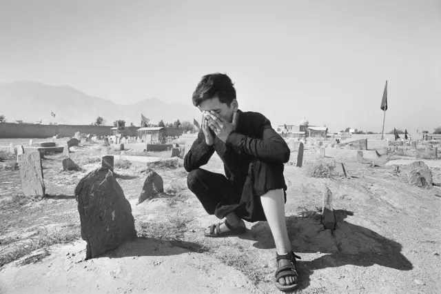 Medy Ewaz Ali reza ante la tumba de su madre en Kabul (Afganistán).