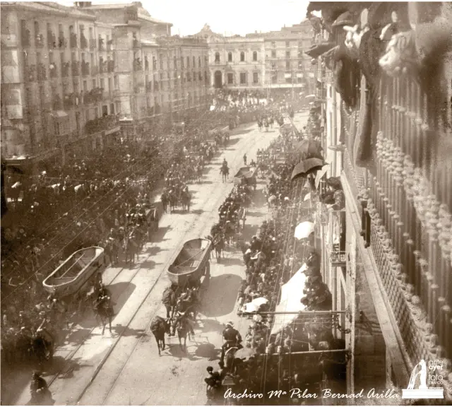 Desde los balcones del Coso zaragozano, el público contempla el paso del regimiento de Pontoneros, que desfila con su material con motivo de la visita de Alfonso XIII en 1903
