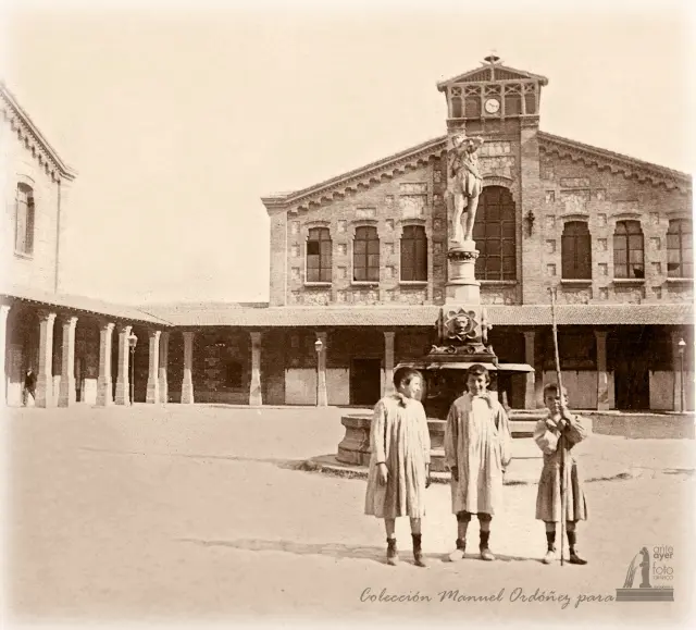 Tres niños posan en el patio del Matadero Municipal, junto a la fuente del Buen Pastor, en el barrio de Montemolín. 1903.