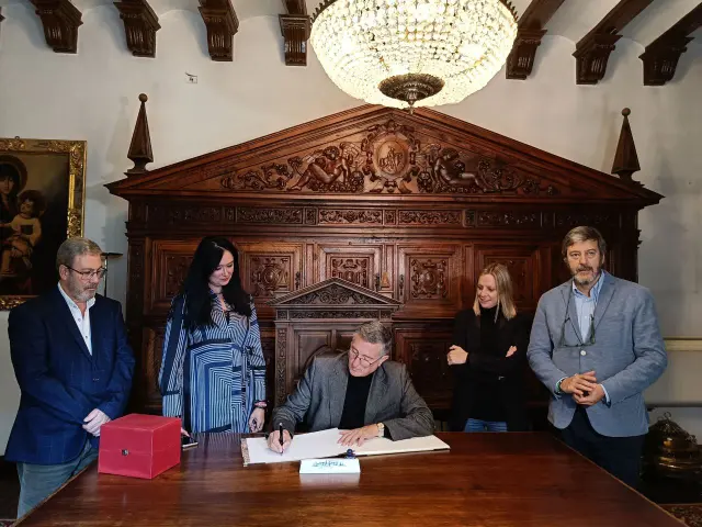El consejero firma en el Libro de Honor del Ayuntamiento de Huesca.