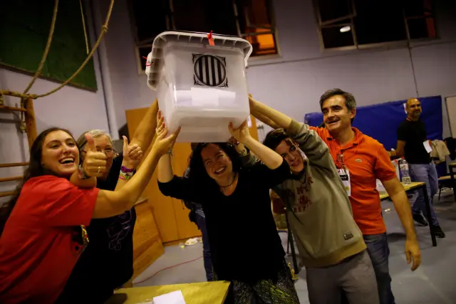 Unos voluntarios alzan una de las urnas usadas en el referéndum del 1 de octubre de 2017