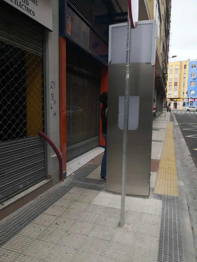El poste de la parada de autobús que ocupa media acera de la calle del Carmen.