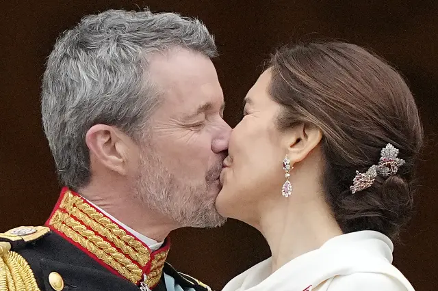 Denmark's King Frederik X kisses his wife Denmark's Queen Mary on the balcony of Christiansborg Palace in Copenhagen, Denmark, Sunday, Jan. 14, 2024. Queen Margrethe II has become Denmark's first monarch to abdicate in nearly 900 years when she handed over the throne to her son, who has become King Frederik X. (AP Photo/Martin Meissner)
