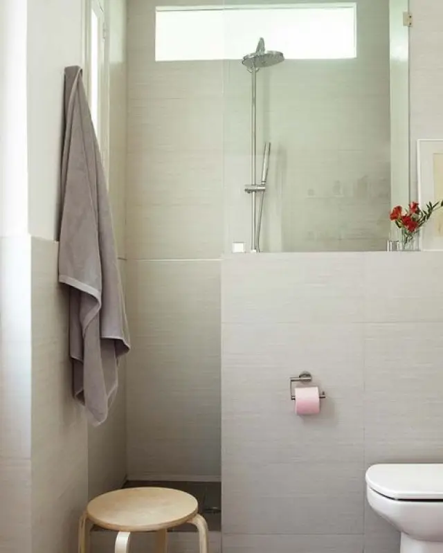 Un murete que hace de separador entre la ducha y el resto del baño.