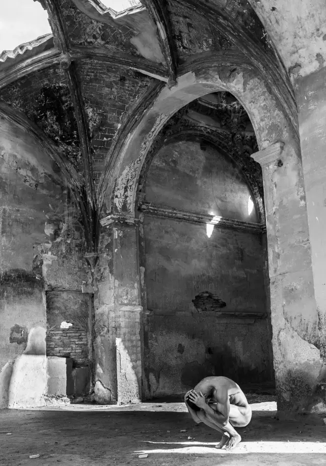 El desnudo, con sus movimientos y sus gestos, enmarcado en el interior de la iglesia que fue bombardeada.