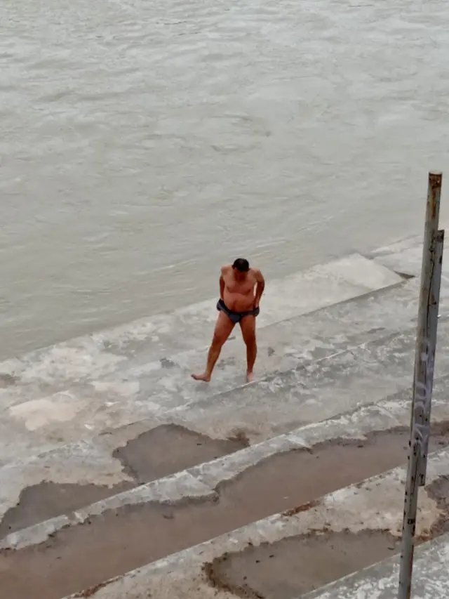 El bañista, al salir del Ebro tras darse el chapuzón.