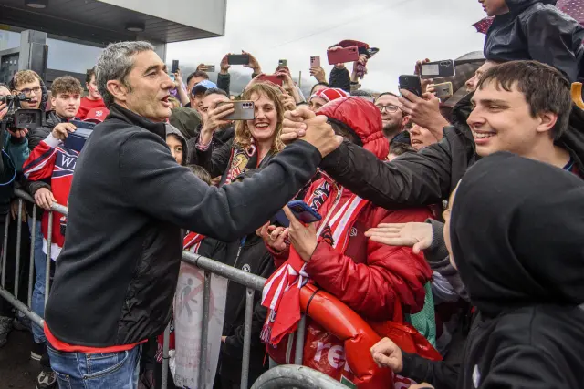 El entrenador del Athletic Club de Bilbao, Ernesto Valverde (i), saluda a los aficionados que han ido a recibirles este domingo en Lezama (Bizkaia) después de ganar ayer sábado la final de la Copa del Rey de fútbol