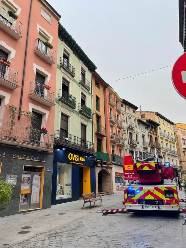 Los bomberos de Huesca utilizando em camión con escalera para evacuar a dos inquilinos y su mascota del edificio que sufrió el incendio.