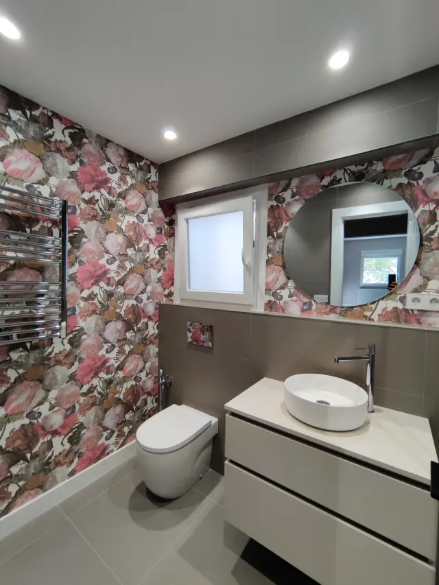Un baño de una vivienda de Zaragoza que utiliza papel pintado en una pared para dar acento.