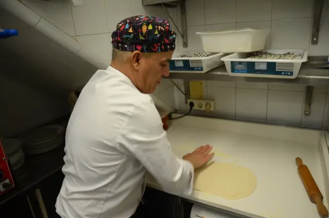 Taoufik Akhrib, preparando una pizza en la cocina.