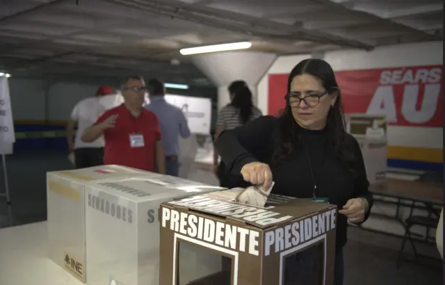 Una votante deposita su voto en la urna para elegir al presidente.