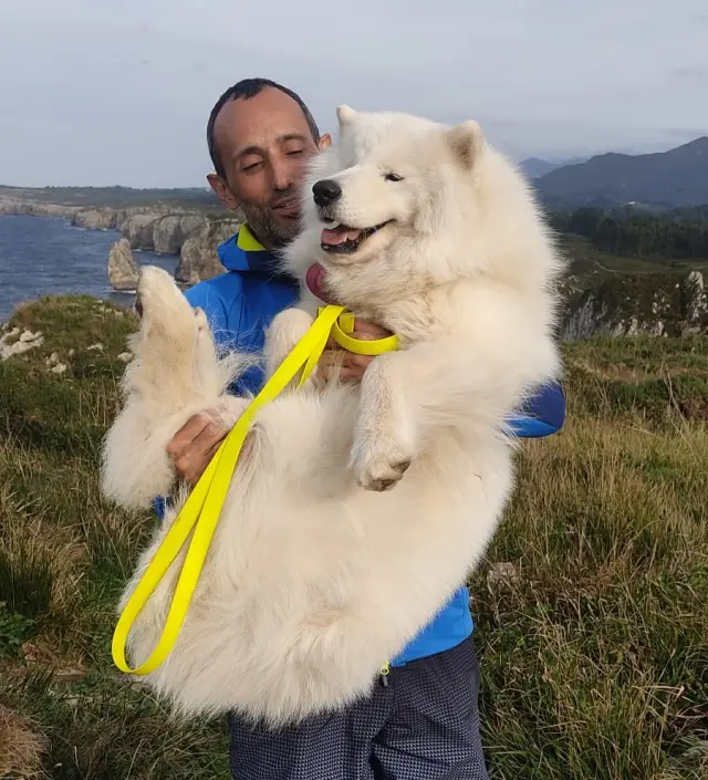 Olmo Uscaga con Lleó en brazos, el perro perdido en el Bisaurín, en el Pirineo oscense.