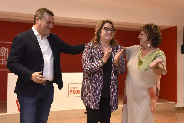 Rosa Serrano, en el centro, recibe la felicitación de Fernando Sabés y Elisa Sancho en la sede del PSOE en Huesca.