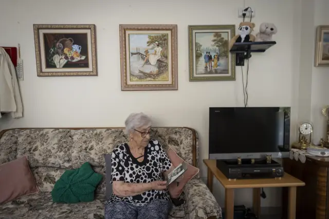Manolita observa la fotografía de su marido Vicente en el sofá de su apartamento tutelado.