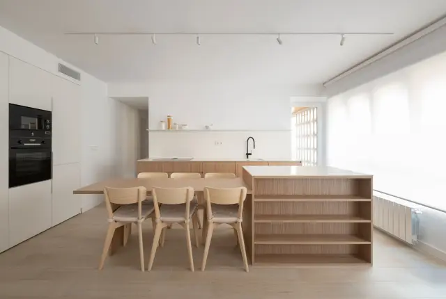 La cocina-salón de la Casa Ópalo, de DANA Arquitectos, con algunas opciones de almacenaje alternativas a los armarios altos.