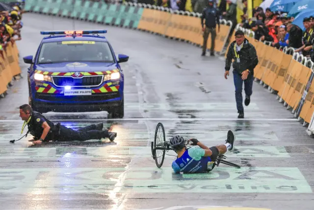 El policía y el espontáneo, en el suelo antes de la meta, en la 17ª etapa del Tour de Francia el pasado 23 de julio, en Valence (Francia) 