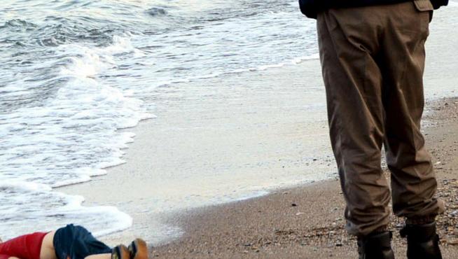 Un gendarme se acerca al niño kurdo sirio Aylan Kurdi, que yace muerto en la playa turca de Bodrum.