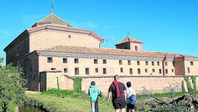 Tres niños contemplan el antiguo convento de Gea de Albarracín, ahora convertido en residencia.