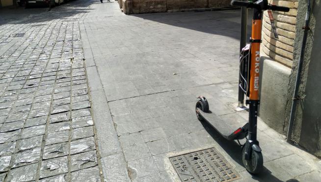 El patín, con el boletín de denuncia, en la acera de la calle de Agustines, junto a la Audiencia de Zaragoza.