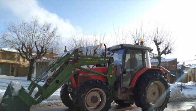 El alcalde de la localidad, Fernando Sánchez, despejando de nieve las carreteras del pueblo con su tractor.