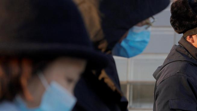 Un grupo de personas con máscaras, en Beijing.