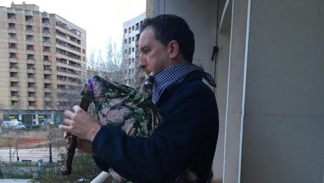 César Marcén toca la gaita en la terraza de su domicilio de Zaragoza para animar el confinamiento por coronavirus.