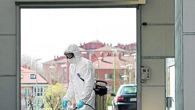 Un bombero desinfecta la entrada de Urgencias del hospital de Burgos.