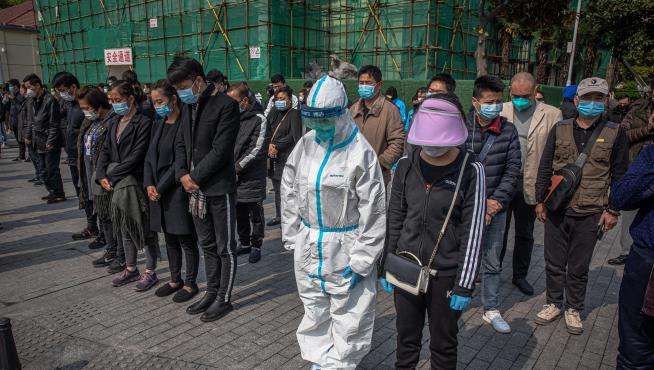 Varias personas, durante los tres minutos de silencio en China por las víctimas del coronavirus.