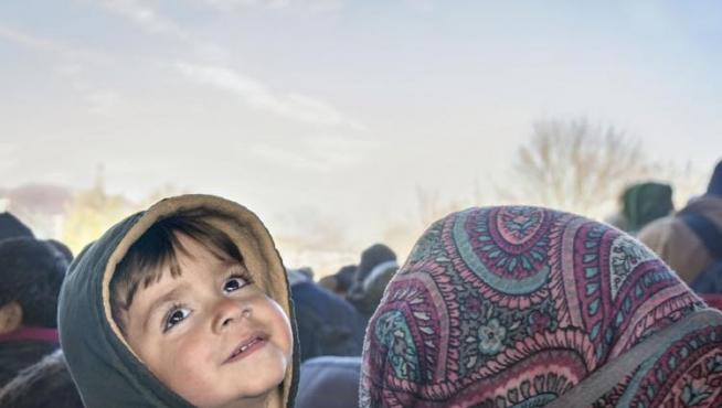Un niño sirio refugiado sonríe en brazos de su madre en la frontera entre Eslovenia y Austria en noviembre de 2015 Foto: Gervasio Sánchez