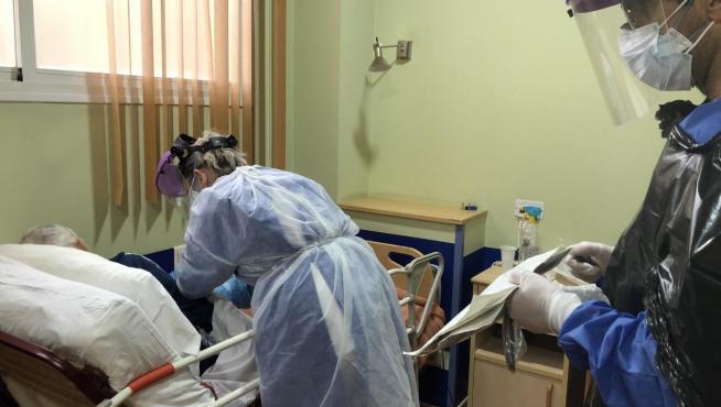 Una doctora y un enfermero atienden a un anciano con coronavirus
