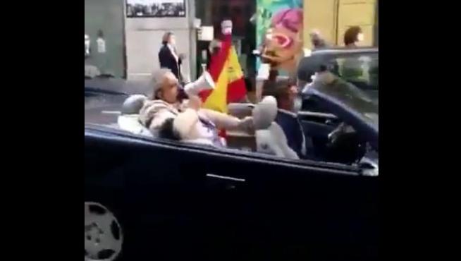 Un ciudadano protesta montado en un descapotable por una calle de Zaragoza.