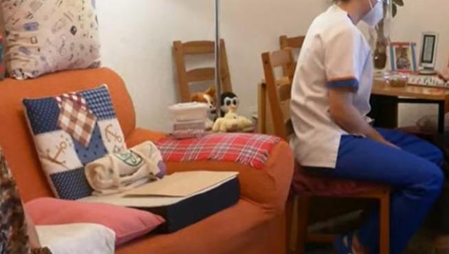 Mercedes Alcázar, en su casa, con marido Paco atendido por una trabajadora del Centro Alzheimer Huesca.
