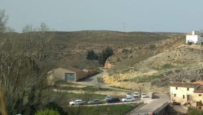 Coches aparcados en la carretera sobre la presa romana que es Bien de Interés Cultural (BIC)